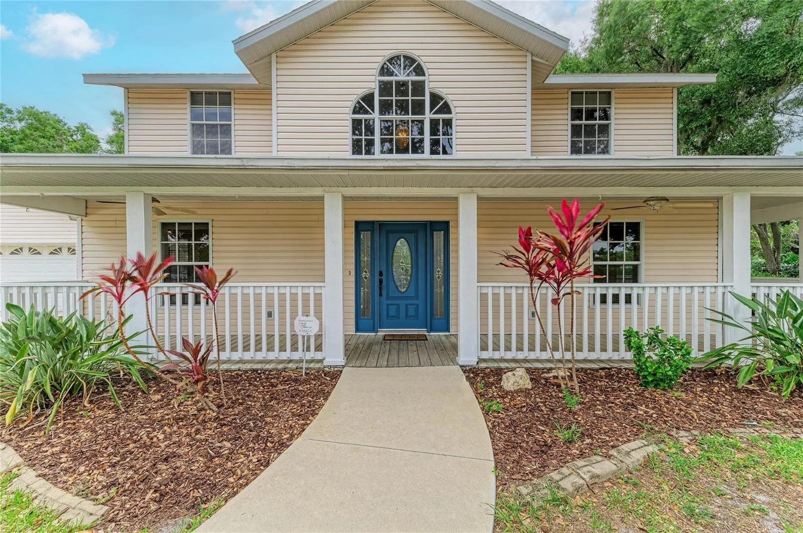 Front of home with wrap around porch and Palladian window
