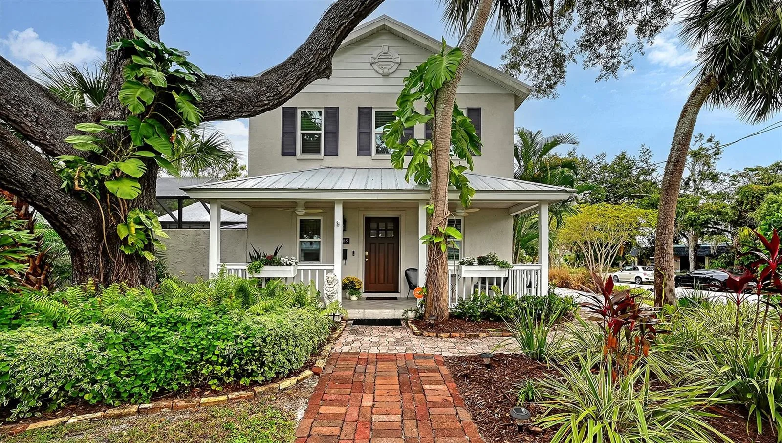 Beautifully landscaped Key West–inspired residence welcomes you with timeless architectural character, mature tropical landscaping, and an impressive oak tree.