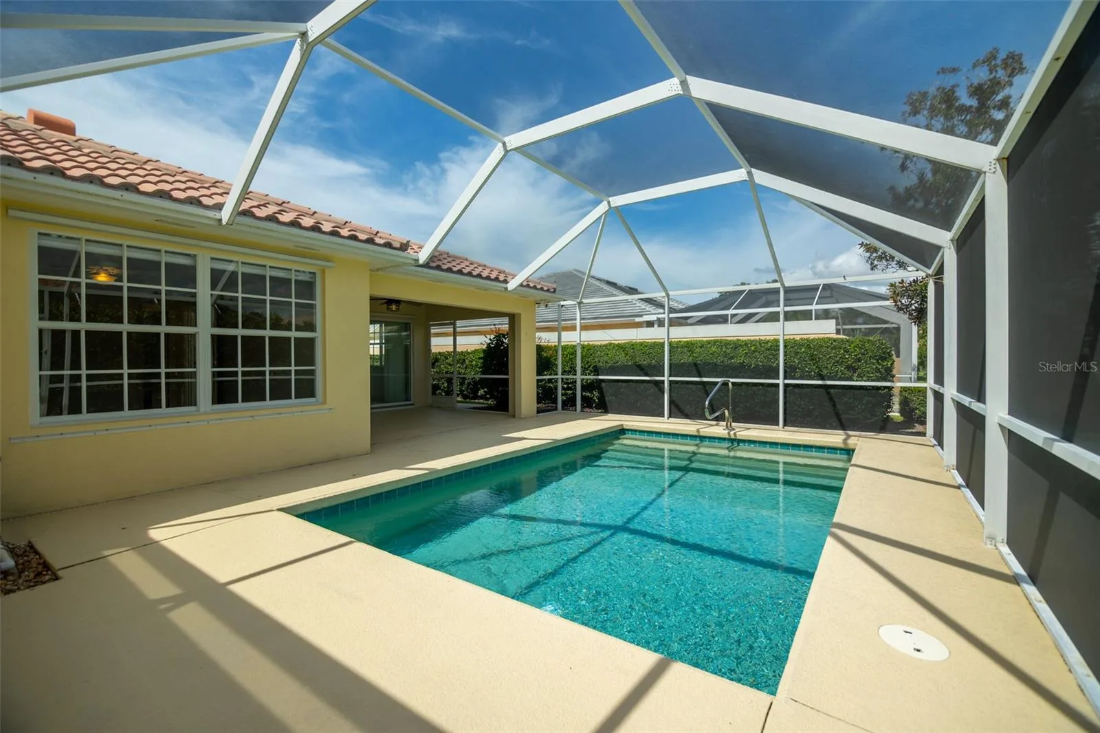 Pool Deck with view of covered patio and primary suite window.